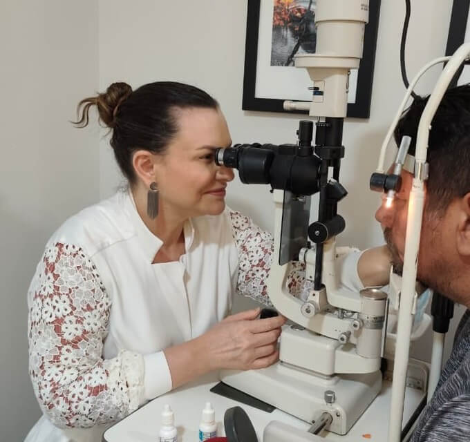 Dra. Cristiane Carvalho examinando paciente em consulta oftalmológica